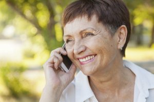 beautiful woman of 50 years with a mobile phone outdoors