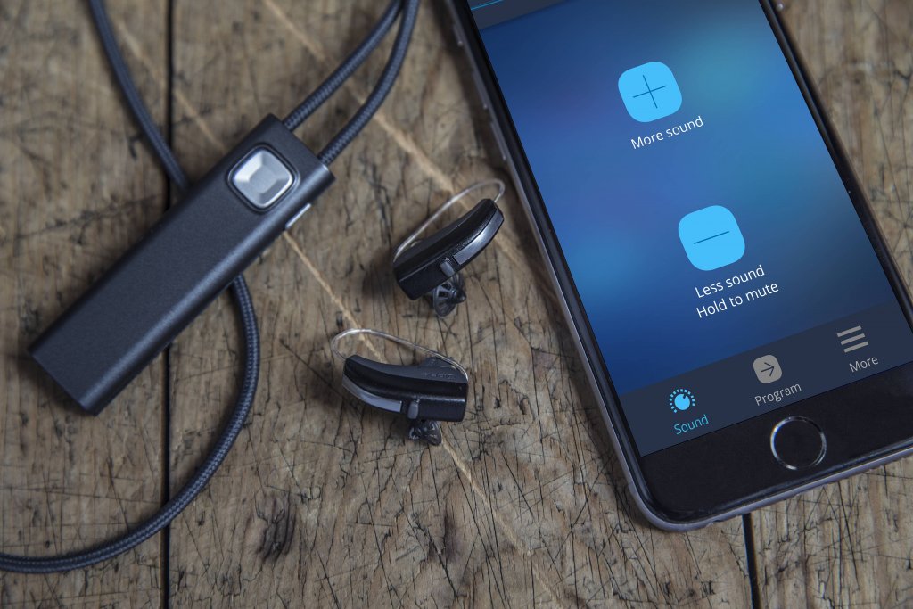 com-dex next to hearing aids and iphone with com dex app